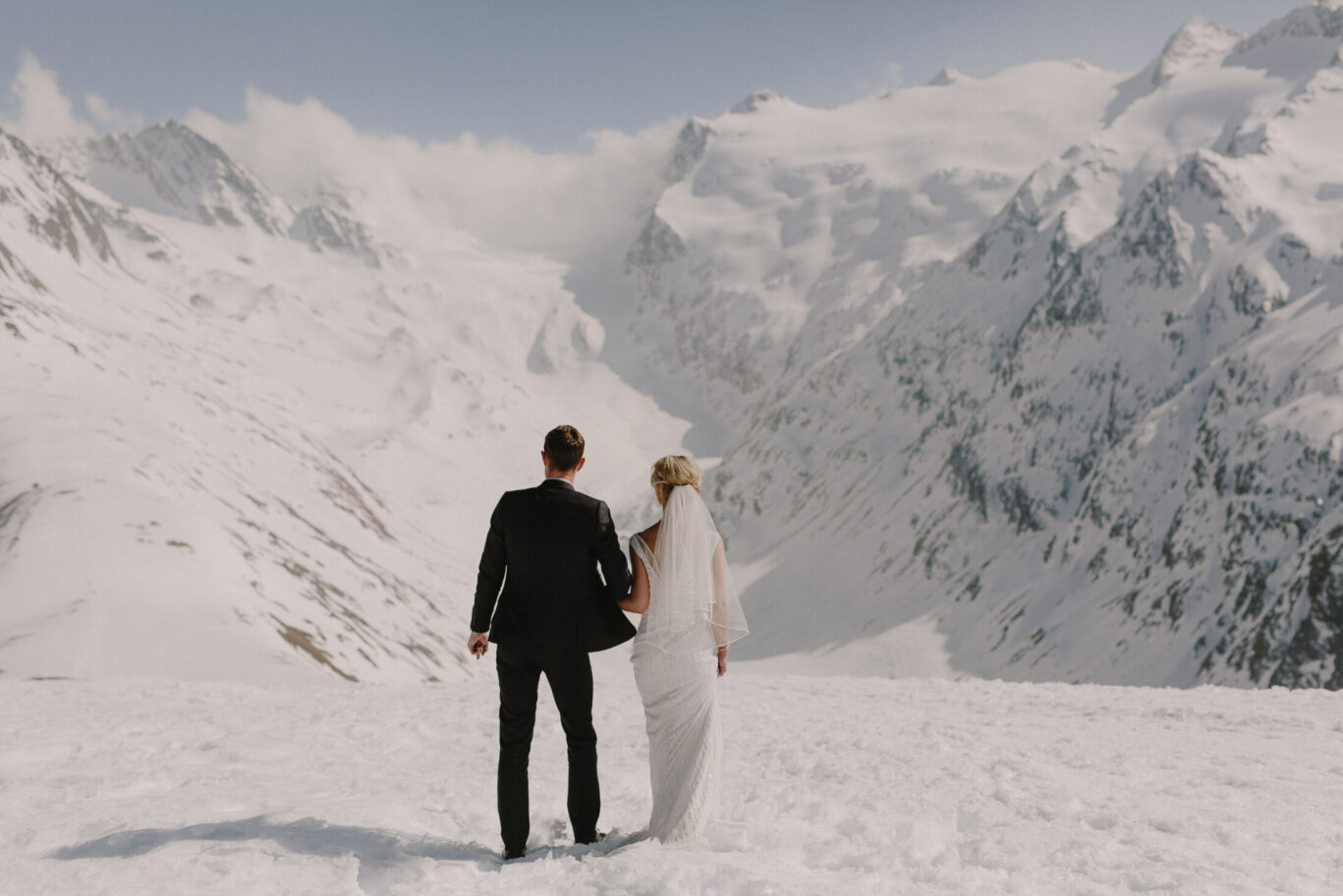 bride and groom standing on top of mountain