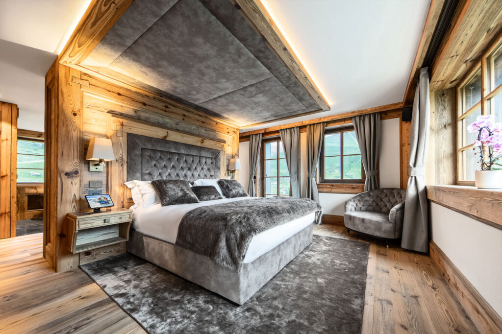 luxury italian ski chalet bedroom with grey linen and throw