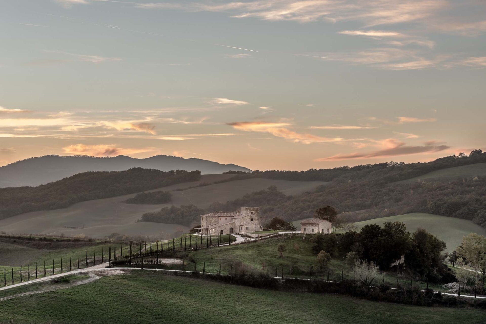 Villa near Siena Tuscany at sunset with rolling hills in background