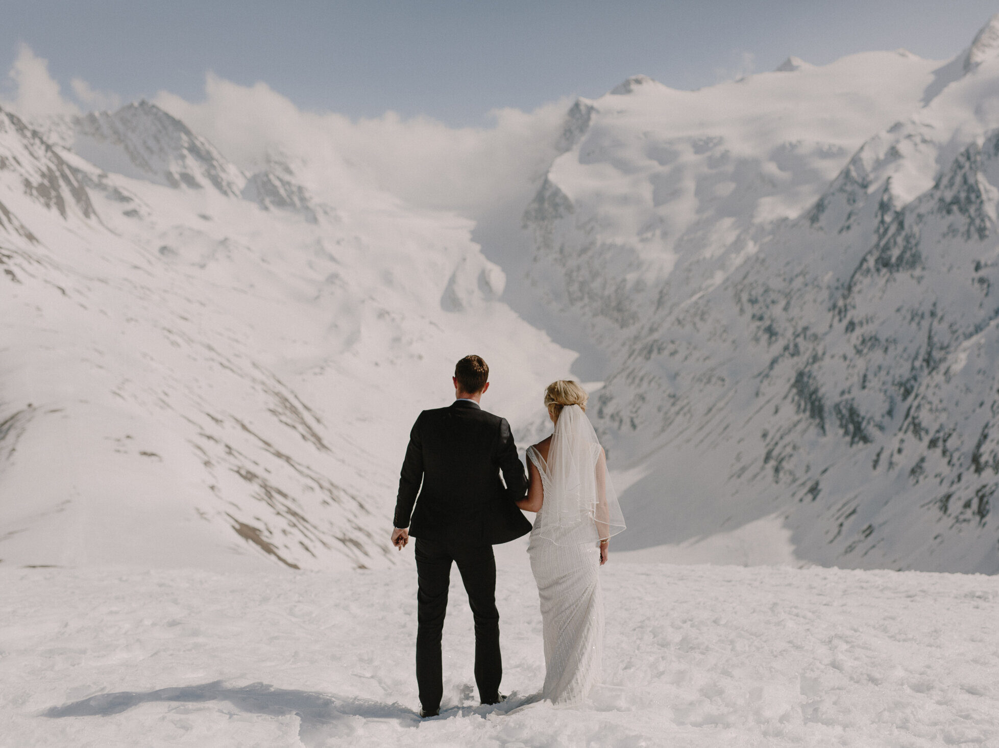 bride and groom standing on top of mountain
